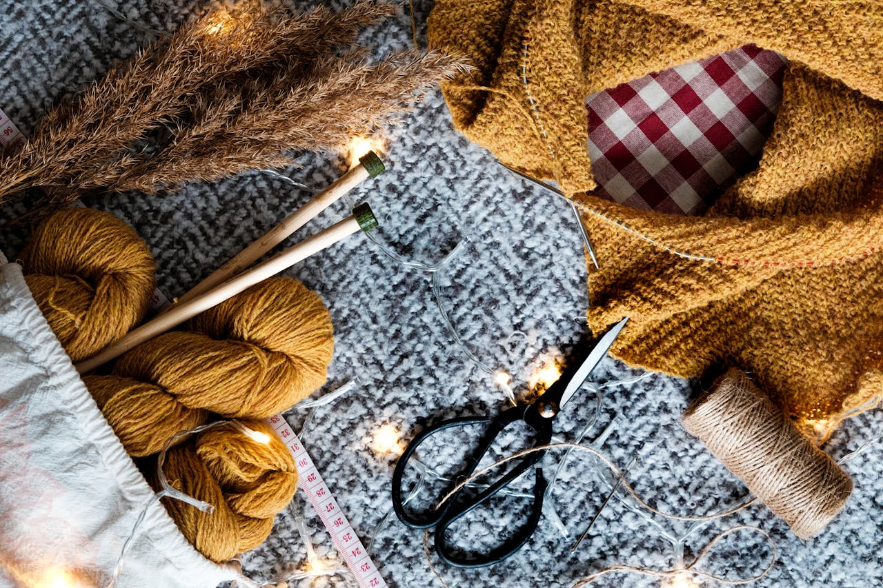 Discover cozy mustard yarn, knitting needles, and crafting tools in this inviting setup.