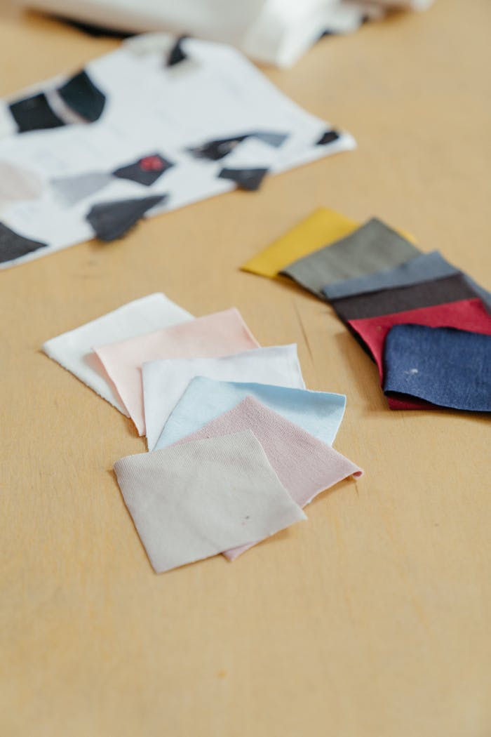 Diverse fabric swatches displayed on a wooden table, ideal for design projects.